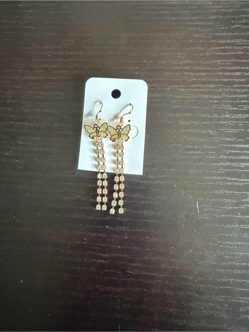 Gold-toned butterfly dangle earrings featuring rhinestone tassel chains.